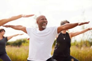 exercise and good health, a group men and women in an outdoor Yoga class